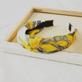 Detail eines gelben Satin-Haarreifs mit Retro-Kettenmuster und Knotendesign - Gelb