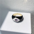 Makroaufnahme von breitem schwarzem Emaille-Ring mit bösem Auge und lila Edelstein-Mitte - Schwarz & Weiß