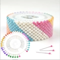 Colorful pearl head pins arranged in a round white storage wheel for sewing and pinning - Colorful