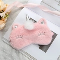 Detailed view of pink plush unicorn sleep mask with silver horn on a magazine - Pink Unicorn