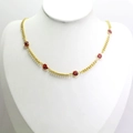 Détail d'un collier chaîne dorée avec cinq breloques œil rouge sur un mannequin blanc - Rouge