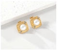 Detalle de pendiente cuadrado con perla y diamantes sobre una superficie de piedra - Dorado
