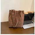 Braune Cord-Beuteltasche mit Erdbeermuster und doppelten Trägern auf Holztisch - Braun