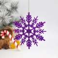 Sparkly purple glitter snowflake ornament hanging on a festive Christmas tree - Deep purple