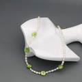 Dettaglio della collana di perle d'acqua dolce con margherite verdi su un manichino bianco - Verde