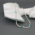 Dettaglio della collana di perle d'acqua dolce con fiori blu su espositore a busto - Blu