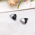 Close-up of heart-shaped magnetic clasp pendants in silver and black on marble surface - Heart Black & White (20x6mm)