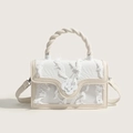 Chic canvas crossbody bag with fringe details and floral clasp in cream and white - White