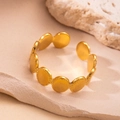Close-up of a gold hollow star ring with diamond setting on a natural stone base - Oval Connection