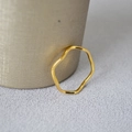 Dettaglio macro di un anello minimalista ondulato in ottone placcato oro lucido - US 6 / Placcato Oro Onda