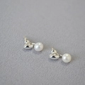 Detailed view of freshwater pearl earrings with polished silver metal on grey fabric - Silver