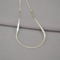 Macro shot of silver flat snake chain necklace with high-polished metallic texture - Silver Tone Flat Snake Bone Chain / Silver