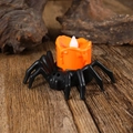 Detalle de vela LED de Halloween con base de araña negra sobre fondo de madera - Luz Trasera de Araña