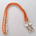 Close-up of woven orange and white shoulder strap with gold metal hooks and leather tabs - 80cm / Orange