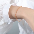 Minimalist gold chain bracelet featuring vibrant orange resin beads on a model wrist - Bracelet / Orange