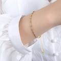Minimalist 18K gold bracelet with grey-blue enamel beads on a silk shirt sleeve - Bracelet / Gray