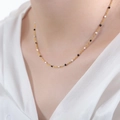 Chic 18K gold chain necklace with minimalist black and white beads on a model - Necklace / Black and White