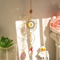 Golden suncatcher with crescent moon and star pendant casting rainbow light on window - QHM3447 Star Moon Suncatcher