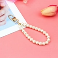 White glass pearl lanyard keychain with gold lobster clasp on pink background - Cream White Pearl + KC Buckle