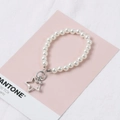 Handmade white glass pearl keychain with a silver star charm on a pink background - Silver Star