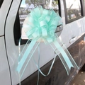 Detail of mint green macaron pull bow ribbon tied to a vehicle rearview mirror for decor - Tiffany Green