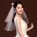 Short two-layer white bridal veil with bow ribbon detail on model with brown background - White Double Layer with Pearl Bow / Alloy Hair Comb
