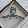 Detailed top view of a large transparent claw clip with black lace mesh and gold spring - Cross / Black