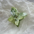 Detailed close-up of butterfly hair claw clip with green and white marble pattern texture - Green