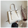 Detail of a white quilted handbag featuring a textured weave design and long shoulder strap - White