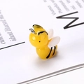 Detailed macro view of a yellow resin bee pendant with wings for DIY jewelry - Bee