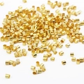Makroansicht von vergoldeten Kupfer-Quetschperlen für Schmuckherstellung und Halsketten - 1.5mm / Gold