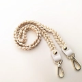 Close-up of woven beige and gold strap with white leather ends and metal lobster clasps - 100cm / All Beige