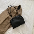 Minimalist black crescent shoulder bag with round eyelet detail and slender strap - Black