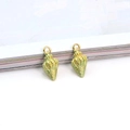 Macro detail of gold-plated seashell charms with light green oil-drip enamel finish - Green Conch