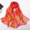Detail of long red chiffon scarf with autumn leaf print and care label information - Multicolor Leaf Red