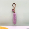Purple plush keychain with fringe tassel and rose gold metal ring in a minimalist layout - Purple