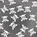 White skull and crossbones confetti decorations scattered on a dark textured background - White Skull