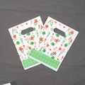 Detail of floral plastic gift bag with green plaid base and oval die-cut handle - No.7 Floral Grid