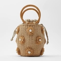 Detailaufnahme der Strohtasche mit handgewebten Blumen und weißen Perlenverzierung - Originalfarbe