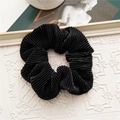 Detailed view of black pleated velvet scrunchie featuring elegant textured fabric ripples - Accordion Pleated / Black