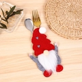Close-up of Christmas gnome cutlery holder with red hat on wooden dining table decor - Heart Style