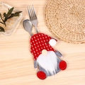 Detail of Christmas gnome cutlery holder with fork and spoon on wooden table background - Polka Dot Style