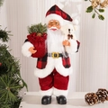 Close-up of standing Santa figurine with red velvet outfit holding a gift bag and bear - 12 Inch Gift Bag Style