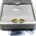 Detailed close-up of golden hoop earrings with white zircon flower pendants on jewelry box - Gold White Zirconia