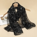 Dettaglio di sciarpa in chiffon nero leggero con note musicali bianche e trama trasparente - Note Musicali Bianco e Nero