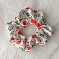 Detail of Christmas scrunchie with holly leaves and berry patterns on white satin - Style 1 (White Christmas Print)