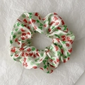Detailed close-up of cream satin scrunchie with festive Christmas tree and hat patterns - Style 8 (Cream Red Green Christmas Hat)