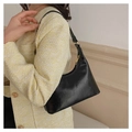 Close-up of a black PU leather baguette bag worn with a yellow tweed jacket and gold hardware - Black