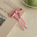 Close-up of a pink bow hairpin on a book, showcasing the smooth resin material texture - 8.5cm / Pink