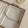 Detalle de diadema de acetato de carey azul y amarillo en una bandeja de madera decorativa - Floral Azul PVC